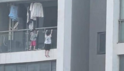 吓人！幼童爬到13层阳台外悬空玩“引体向上”，街道办：已告诫家长加强看护